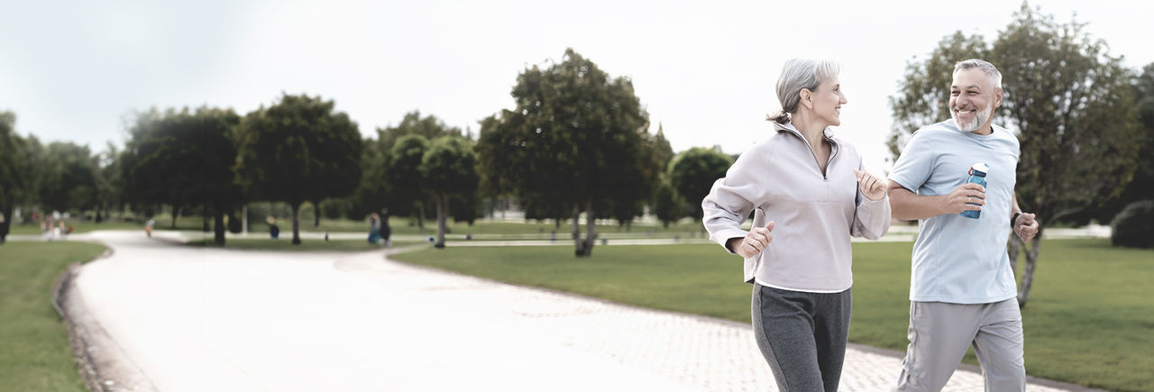 Mann mittleren Alters und Frau laufen und werben für die Behandlungsoptionen von Boston Scientific